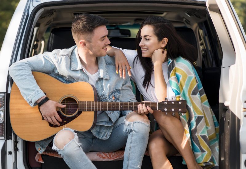 couple-sitting-in-trunk-with-guitar